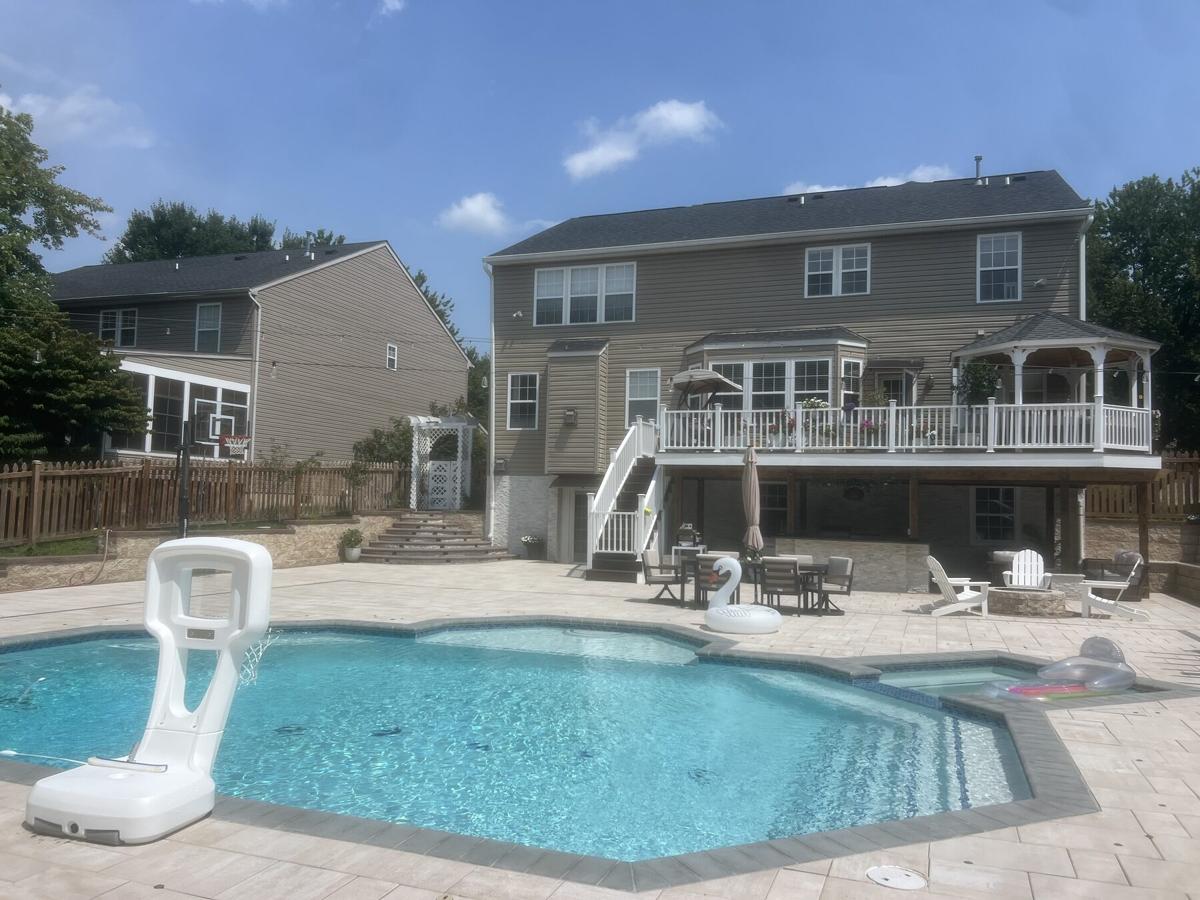 Finished backyard remodel with in-ground pool, paver deck, and railed deck with gazebo