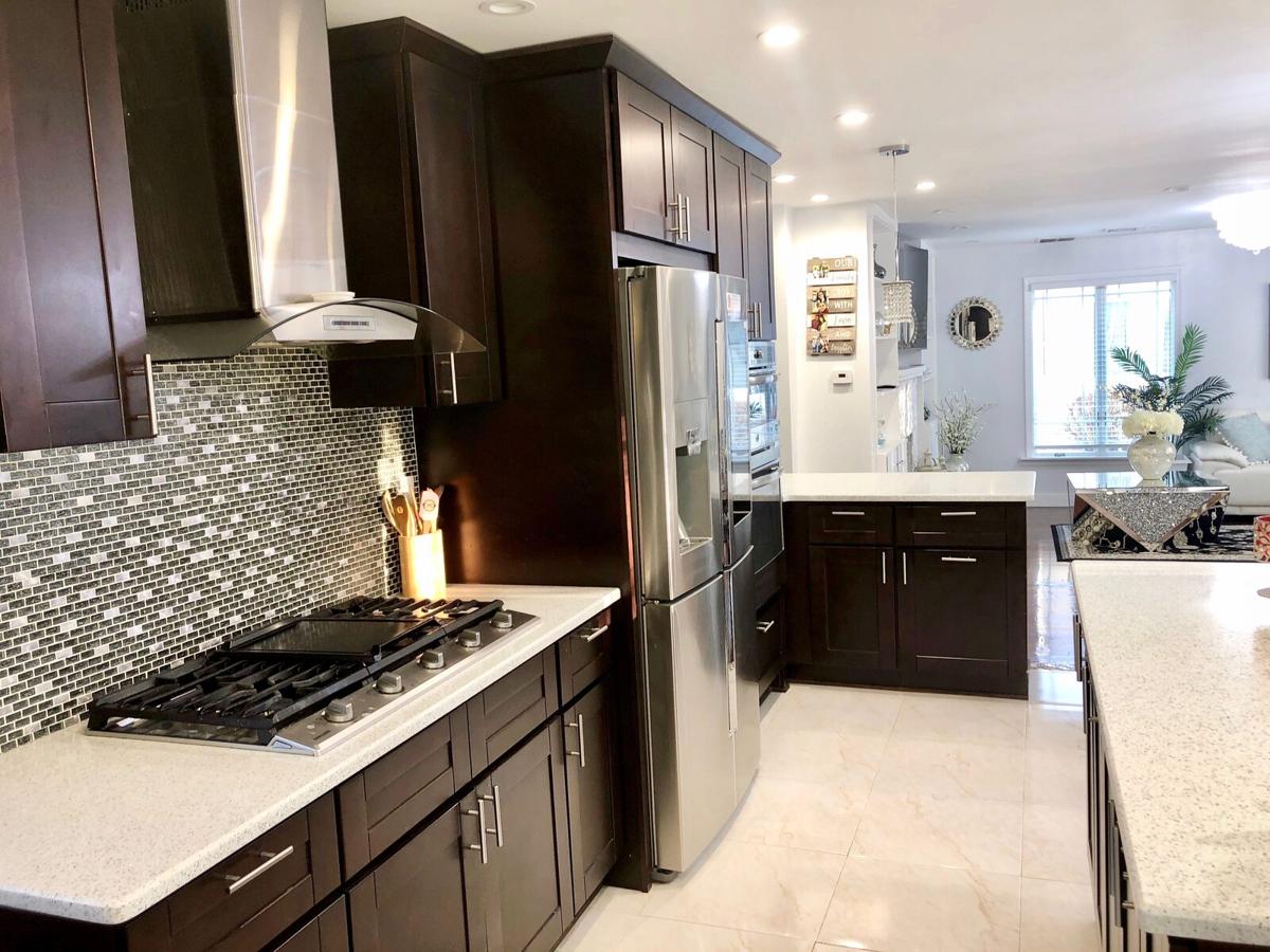 Remodeled kitchen with espresso cabinets, quartz counters, and mosaic tile backsplash