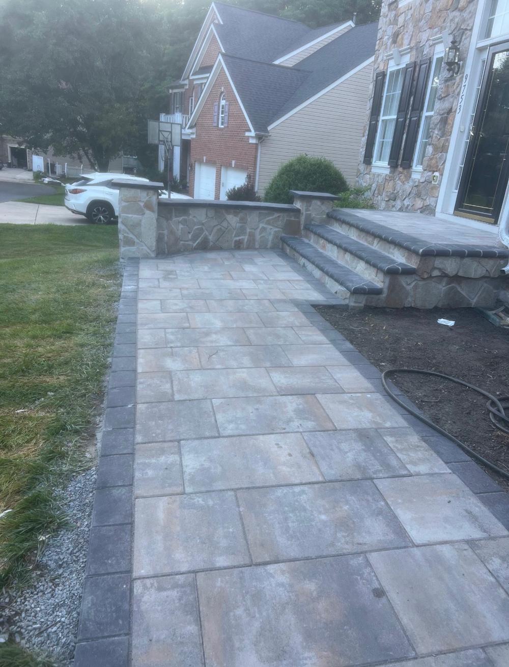 Paver walkway, stone seat wall, and steps completed by ARM Construction Group